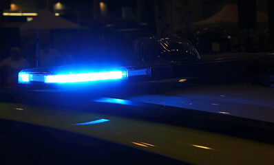 blue flashing of a police car during the night patrol around the city