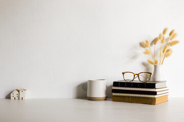 Working items with glasses, flowers and books on wooden table. 