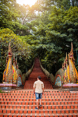 Joven hombre adentrándose a templo budista Doi Suthep, en Chiang Mai, Tailandia	