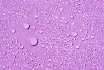 Liquid drops on a lilac background Natural sunshine and shadows. Skincare products. Beauty concept for face and body care in top view.
