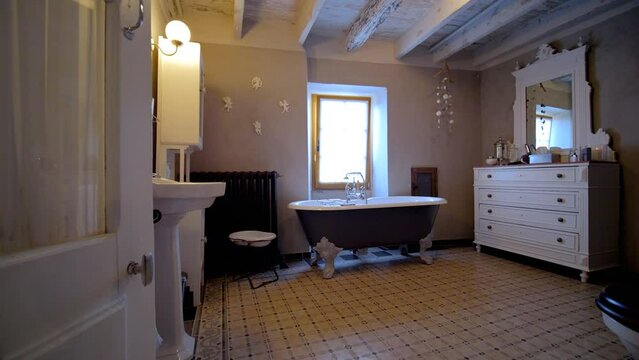 Entering vintage bathroom with free standing tub and wood roof beams, Dolly in shot