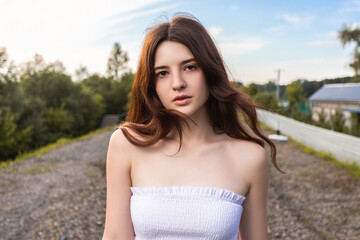 Naklejka premium Portrait of a beautiful young woman looking seriously at the camera while enjoying the afternoon on a sunny summer day. Woman self-confidence and independence concept