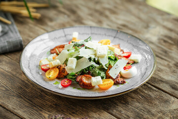 Portion of caesar salad with chicken on wooden table