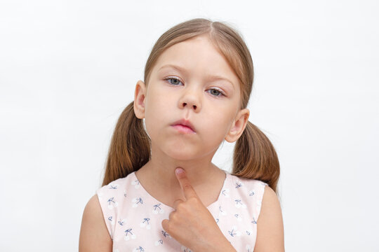 Portrait of caucasian little girl of 6 years pointing at throat by index finger showing voiceless and speechless. Concept dysarthria, logopedics