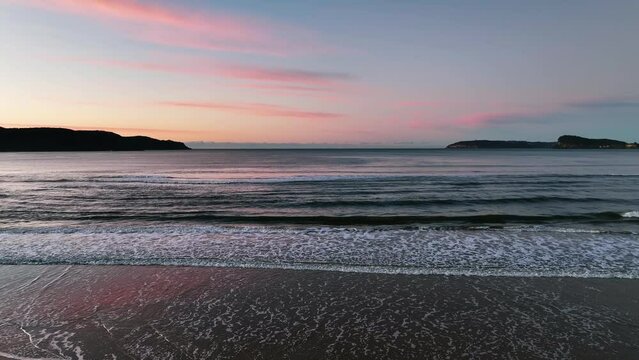 Gentle Winter sunrise at Ocean Beach in Umina Beach on the Central Coast, NSW, Australia.