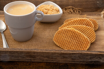 une tasse de café et gaufres au brownie sur un plateau en bois