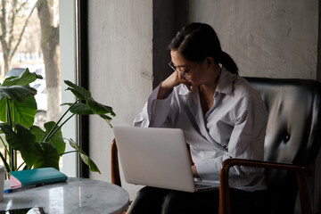 Business asian woman working on laptop and reading required information, look like serious and...