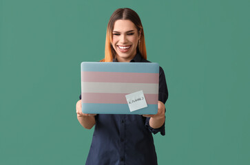 Happy transgender programmer with laptop on green background - obrazy, fototapety, plakaty