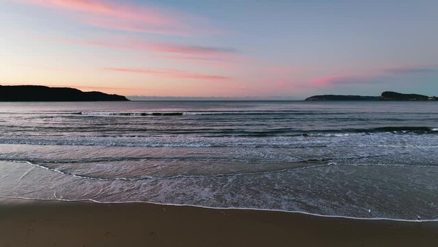 Gentle Winter sunrise at Ocean Beach in Umina Beach on the Central Coast, NSW, Australia.