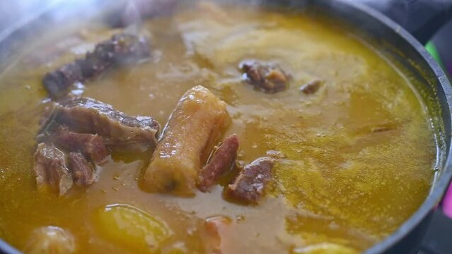 Close up of wooden ladle stirring traditional Dominican creole food called Sancocho