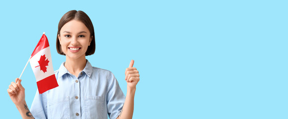 Beautiful young woman with Canadian flag showing thumb-up on light blue background with space for text - obrazy, fototapety, plakaty