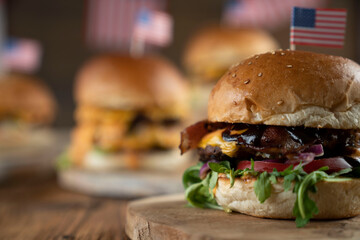 Fourth of July celebration. American flag and decorations. Burgers on rustic wooden table.