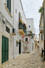 A narrow street among the old houses in the historic center of Otranto, a town in Puglia in Italy.