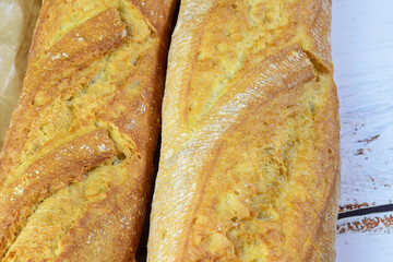 Freshly baked bread on a white rustic wooden table.
