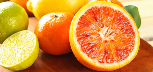 Different ripe citrus fruits on table, closeup