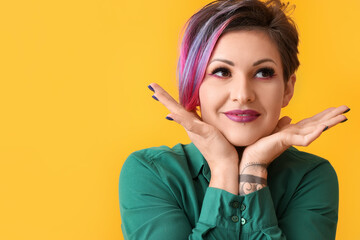 Obraz premium Beautiful woman with short dyed hair on yellow background