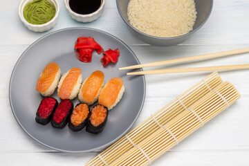 Bamboo mat and sushi set on a gray plate.