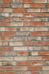 Brick wall with red cracked and damaged stones, background with space for text, vertical format 