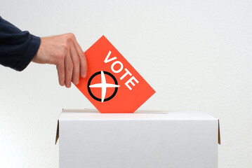 Wählen - Hand mit Stimmzettel und Wahlurne