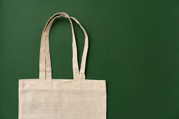 Textile shopping bag on green background flat lay