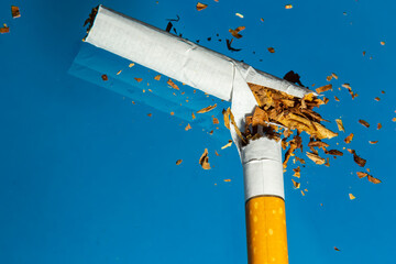 Broken cigarette on blue background. Stop smoking concept photography