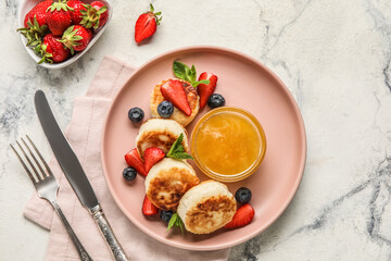 Plate with delicious cottage cheese pancakes, berries and honey served on light background