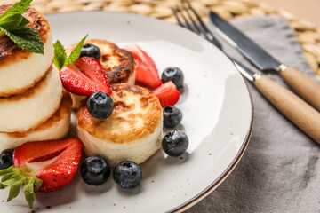 Plate with delicious cottage cheese pancakes, berries and mint leaves, closeup