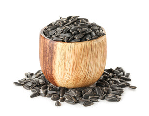 Bowl of black sunflower seeds on white background