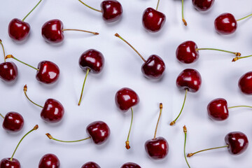 background of ripe cherries with water drops on white background close-up top view