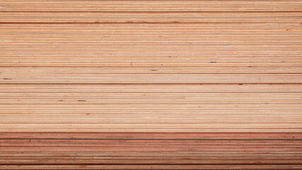 Background of stacked plywood. Cream and brown artificial wood side surfaces with copy space. Selective focus