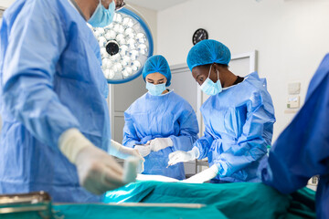 Surgeon team in uniform performs an operation on a patient at a cardiac surgery clinic. Modern...