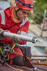 A specialist is repairing the roof. Rope access