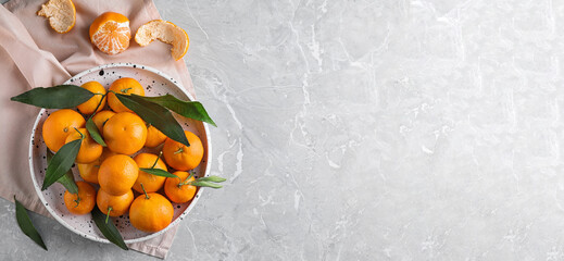 Flat lay composition with fresh ripe tangerines on light grey marble table, space for text. Banner design