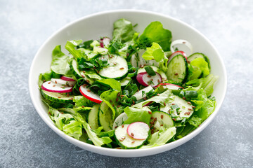 Salad with fresh green lettuce, radish and cucumber