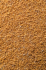 Aromatic mustard grains as background, top view