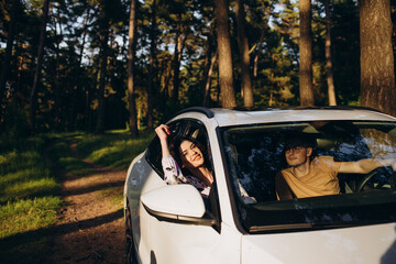road trip, travel, dating, couple and people concept - happy man and woman driving in cabriolet car...