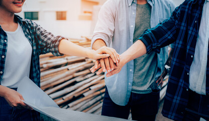 Closeup of team engineer construction workers join hands together on construction site, success collaboration concept.