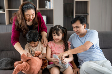 Happy family mother father and kids at home on couch, Cheerful parents playing with their sons at...