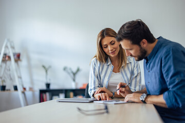 Obraz premium Focused people sitting next to each other, writing something, planning something.
