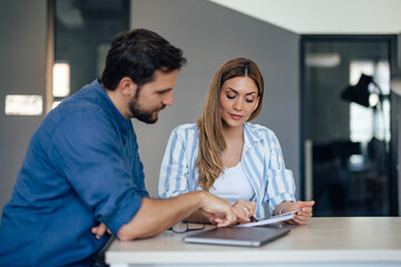 Businessman showing some ideas to his female colleague, working together at the office.