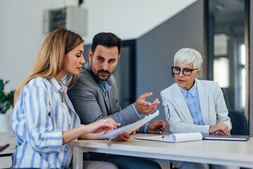 Obraz premium Concentrated businesspeople working together, checking some notes.