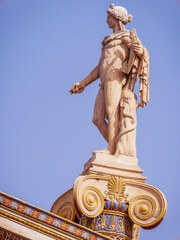 Apollo statue, the ancient Greek god of arts, stands on an Ionian style column at the national academy of Athens, Greece.