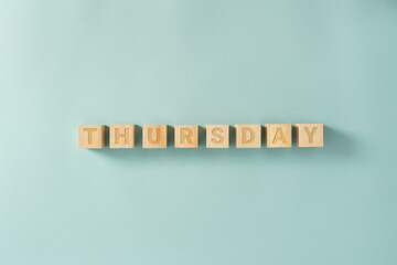 Days of the week written on the wooden cubes on the blue background