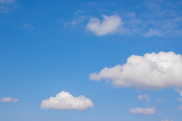 Naklejka na ściany i meble Blue sky with fluffy white clouds background.
