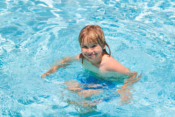 Fototapeta na wymiar Young boy kid child splashing in swimming pool. Active healthy lifestyle, swim water sport activity on summer vacation with child. Child water toys. Children play in tropical resort.