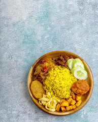 Indonesian yellow rice served with balado eggs, tempeh orek, vermicelli, potato fried chili sauce, where yellow rice is a typical breakfast menu for Southeast Asian people, especially Indonesia.