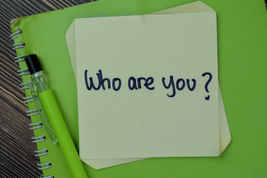 Concept of Who Are You? Identity write on sticky notes isolated on Wooden Table.
