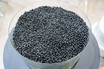 The grain of plastic granules lies in glass form, components of the chemical industry, small crumbs...