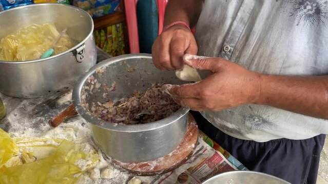 Cooking techniques. Closeup of man hands making purse shape dumpling momo in Darjeeling, West Bengal, India.