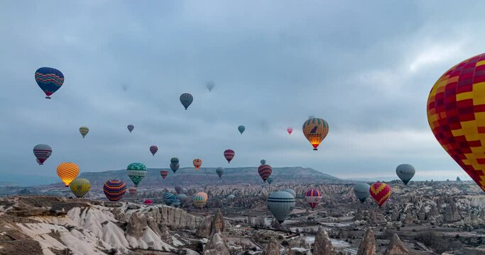 Hot air balloons flying over the valley at Cappadocia, Turkey. Night to day sunrise timelapse.